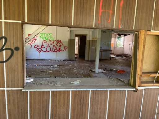 Ein verlassener Raum mit Graffiti und zerstreutem Schutt.